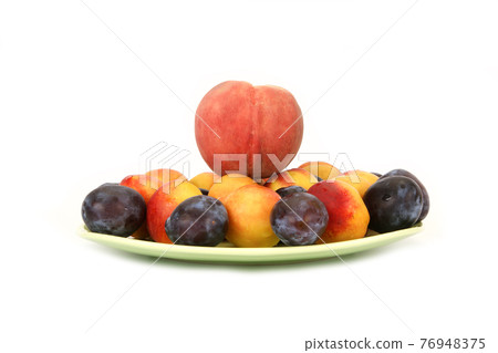 Still life with natural ripe plums and peaches on a white background Still life with natural ripe plums and peaches on a white background 76948375