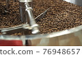 Close view of mixing and grinding roasted coffee beans with equipment 76948657