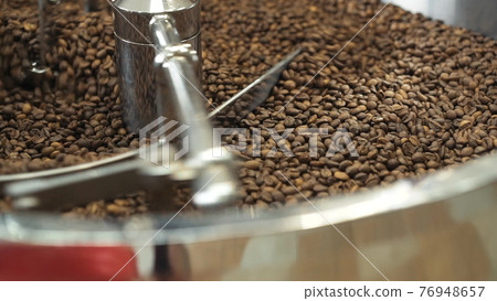 Close view of mixing and grinding roasted coffee beans with equipment 76948657
