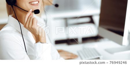 Unknown female customer service representative is consulting clients online using headset.close-up. Call center and business concept 76949246