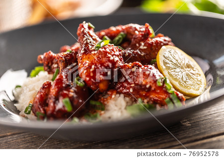 Marinated glazed sticky chicken thighs with seesame served with rice and coriander 76952578