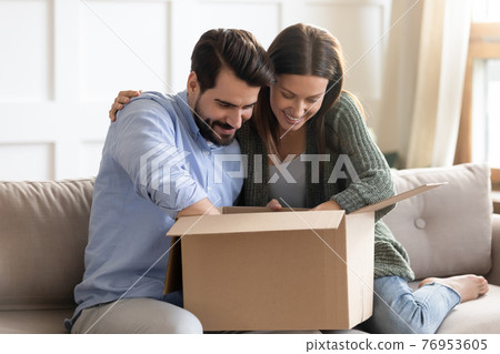 Happy couple unpack box with internet order Happy couple unpack box with internet order 76953605