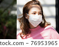 年輕女子站在外面戴著口罩 76953965