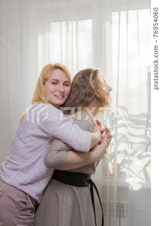 A young girl congratulates her mother on the holiday. A young girl congratulates her mother on the holiday. 76954060