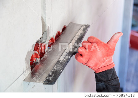 The electrician will plaster holes and channels for sockets and wires. 76954118