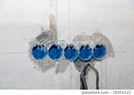 The electrician will plaster holes and channels for sockets and wires. 76954122