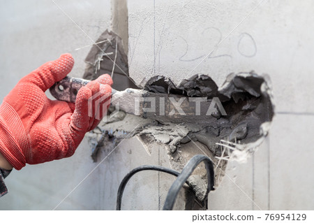 The electrician will plaster holes and channels for sockets and wires. 76954129