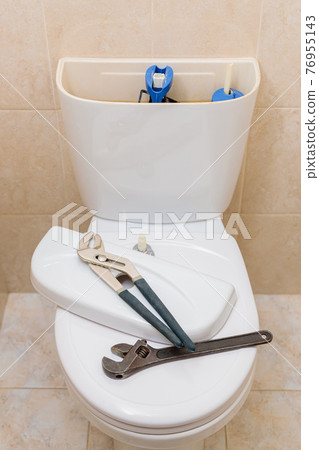 Plumbing tools in the toilet on a white toilet bowl Plumbing tools in the toilet on a white toilet bowl 76955143