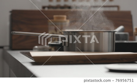steam rising from saucepan on kitchen steam rising from saucepan on kitchen 76956751