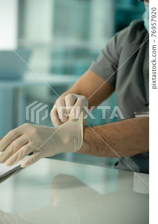Medical researcher putting gloves on hands 76957920