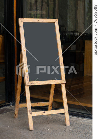 Old whiteboard stand in front of restaurant 76958088