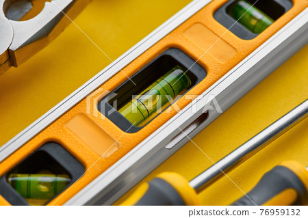 Workshop instrument closeup, yellow background Workshop instrument closeup, yellow background 76959132