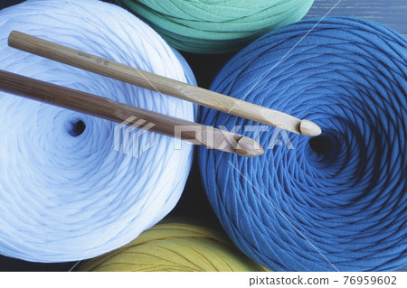Colorful skeins of yarn and crochet hooks . Hobbies, crafts. 76959602