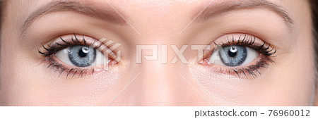 Pair of beautiful deep blue female eyes looking in camera Pair of beautiful deep blue female eyes looking in camera 76960012