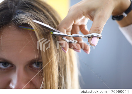 Sad woman at the barber cut bangs close-up Sad woman at the barber cut bangs close-up 76960044