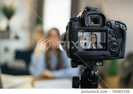 Female influencer using camera for leading live streaming Female influencer using camera for leading live streaming 76960586
