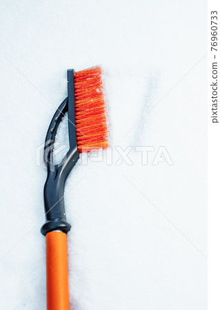 orange snow brush for car, snowflakes background 76960733