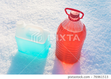 bottle with non-freezing windshield washer fluid, snow background bottle with non-freezing windshield washer fluid, snow background 76961513