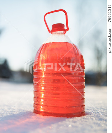 bottle with non-freezing windshield washer fluid, snow background bottle with non-freezing windshield washer fluid, snow background 76961515