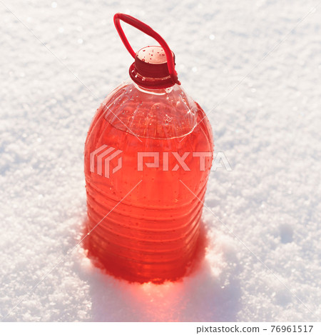 bottle with non-freezing windshield washer fluid, snow background bottle with non-freezing windshield washer fluid, snow background 76961517