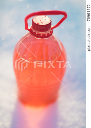 bottle with non-freezing windshield washer fluid, snow background 76961572