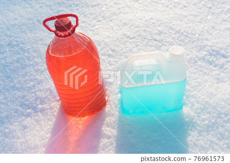 bottle with non-freezing windshield washer fluid, snow background 76961573