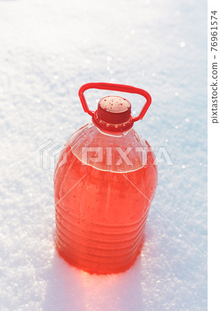 bottle with non-freezing windshield washer fluid, snow background bottle with non-freezing windshield washer fluid, snow background 76961574