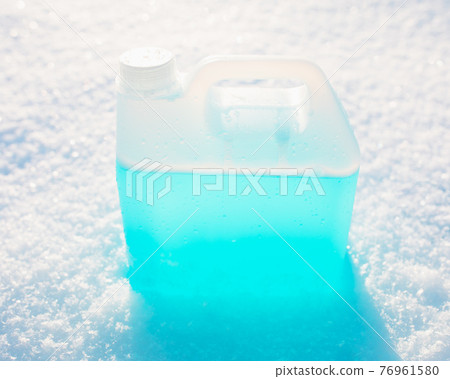 bottle with non-freezing windshield washer fluid, snow background 76961580