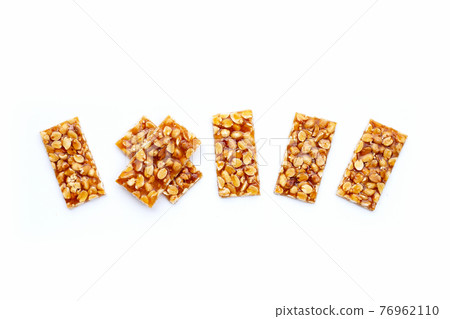 Honey bars with peanuts on white background Honey bars with peanuts on white background 76962110