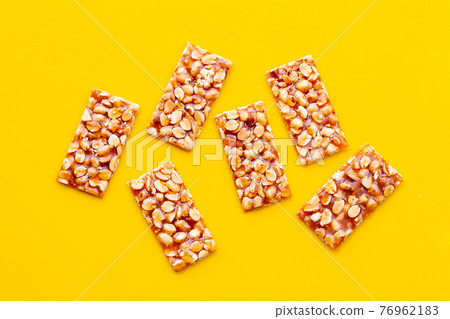 Honey bars with peanuts on yellow background 76962183