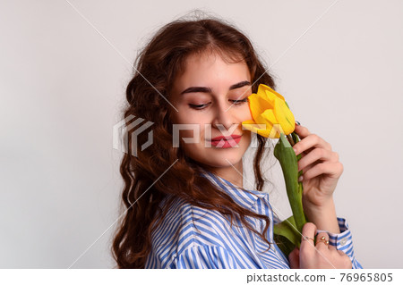 Portrait of a young woman with yellow a tulip flower Portrait of a young woman with yellow a tulip flower 76965805