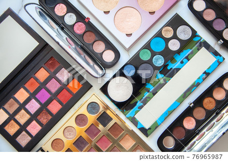 Flat lay of various of waterproof contour, eyeshadow palette collection with vivid and pastel colors 76965987