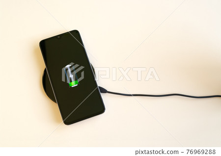 Smartphone wireless charging on induction charger. Wireless charger. Copy space 76969288