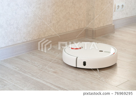 robotic vacuum cleaner on laminate wood floor. robotic vacuum cleaner on laminate wood floor. 76969295