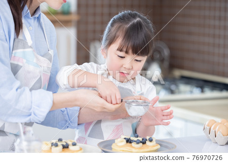 A girl who enjoys making family hot cakes A girl who enjoys making family hot cakes 76970726