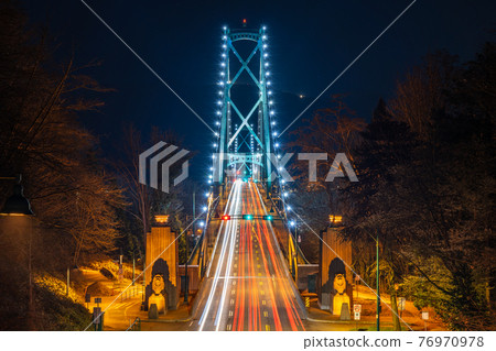 Lions Gate Bridge at night. Cars driving on the bridge with long exposure. Stanley Park, Vancouver, British Colombia, Canada. 76970978