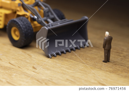 A businessman who stops a wheel loader 76971456