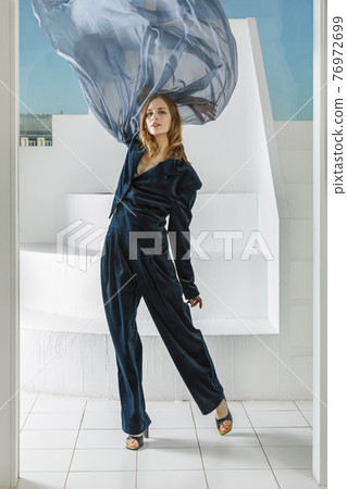 Elegant pretty woman posing with flying fabric 76972699