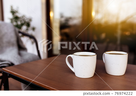 Two cups of coffee on the table on the wooden brown terrace 76974222