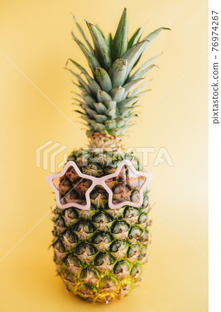 Pineapple with pink star sunglasses. Travel and vacation concept 76974267