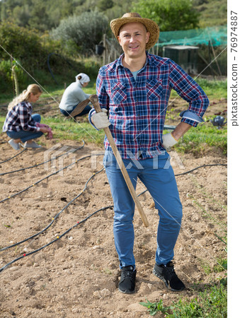 Man gardener with hoe at smallholding 76974887