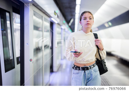 Young european female with mobile waiting the metro Young european female with mobile waiting the metro 76976066
