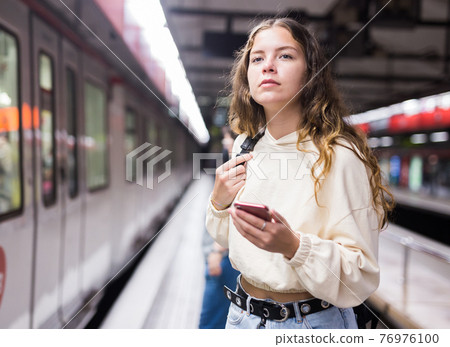 Young european female with mobile waiting the metro Young european female with mobile waiting the metro 76976100
