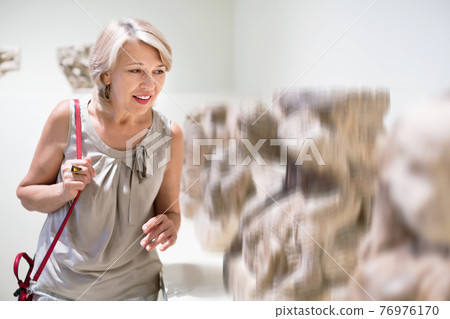 Adult female looking at artwork sculpture in the museum indoors 76976170