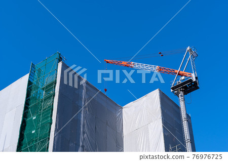 建設中的公寓和起重機高聳於藍天 a-1 76976725