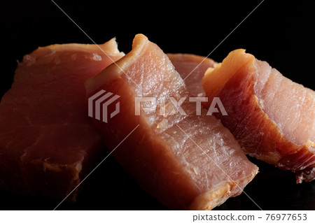 Slices of juicy red meat on a black background Slices of juicy red meat on a black background 76977653