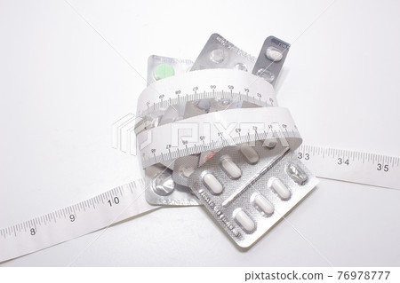 a group of Measuring tape and pills 76978777