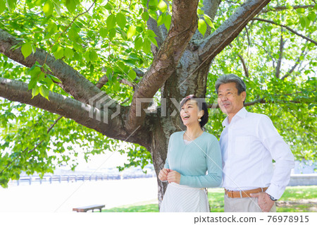 一對老夫婦在大樹下享受著橫濱的生活瓷磚,周圍環繞著新鮮的綠色 一對老夫婦在大樹下享受著橫濱的生活瓷磚,周圍環繞著新鮮的綠色 76978915
