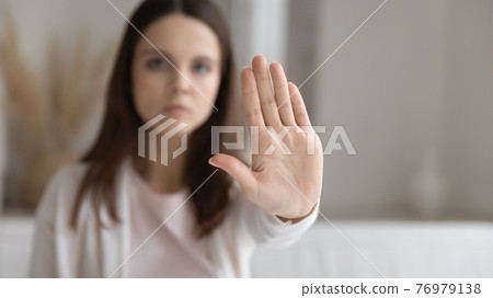 Serious young millennial woman making hand stop gesture at home Serious young millennial woman making hand stop gesture at home 76979138