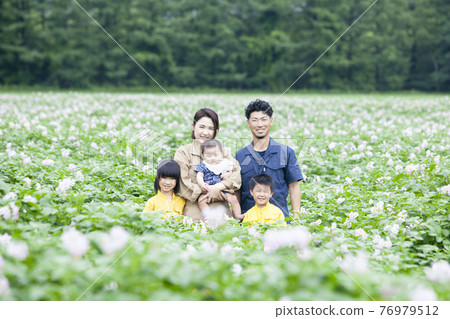 Farmer's family in a potato field 76979512